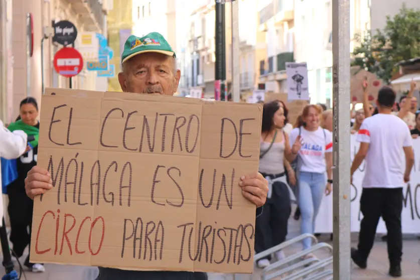 Un manifestante sosteniendo una pancarta en la calle Carretería de Málaga / Península